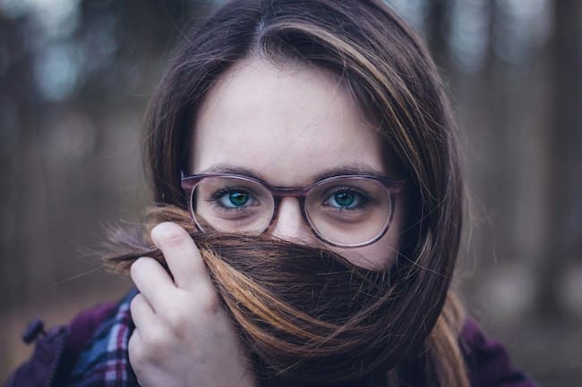 Maksing - Frau hält ihre eigenen Haare vor ihren Mund